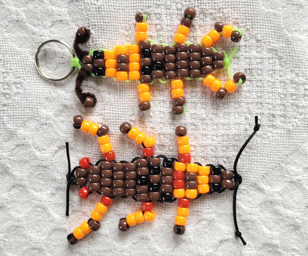 Two cockroaches made out of brown and orange pony beads