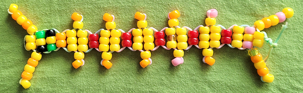 A yellow centipede with accents of warm colours, made of pony beads.