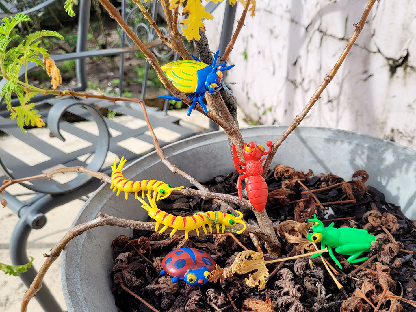 Colourful plastic cartoon bugs in a potted tree