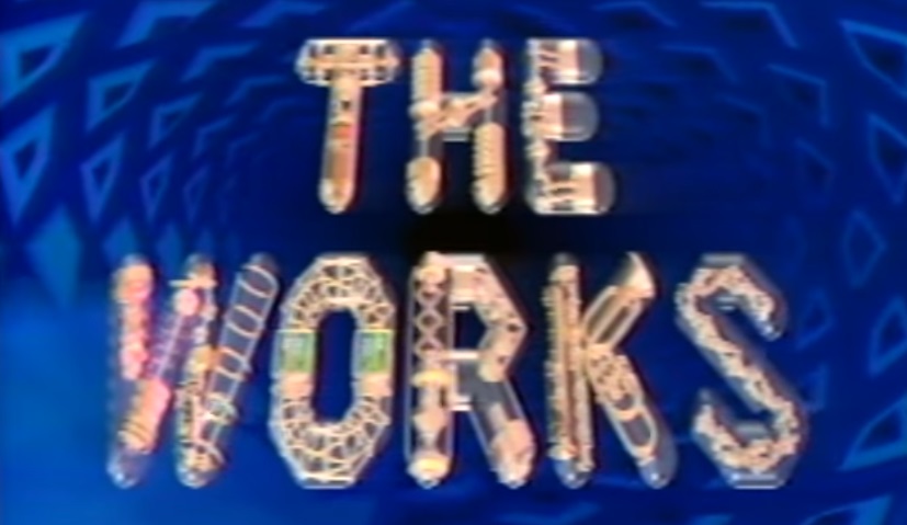 A robotic logo for The Works against a blue checkered background.
